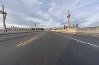 a shot of an empty highway going down the road to cityscape in the distance