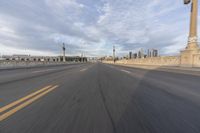 a shot of an empty highway going down the road to cityscape in the distance