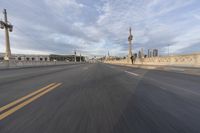 a shot of an empty highway going down the road to cityscape in the distance