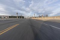 a shot of an empty highway going down the road to cityscape in the distance