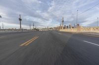 a shot of an empty highway going down the road to cityscape in the distance