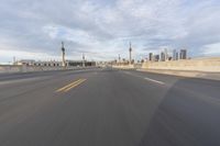 a shot of an empty highway going down the road to cityscape in the distance