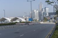 a highway with an empty street going into a big city with tall buildings in the background