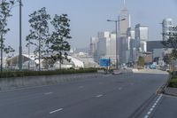a highway with an empty street going into a big city with tall buildings in the background