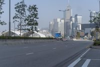 a highway with an empty street going into a big city with tall buildings in the background
