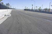 an empty highway with cars traveling on it next to palm trees and buildings in the background