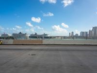 an empty highway in front of the city skylines with cars driving past it on a sunny day