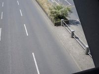 a view down an empty highway towards the beach with cars driving by it in the morning
