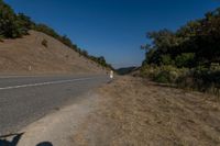 there is an empty highway on this mountain side that appears to be near a hillside