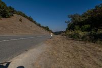 there is an empty highway on this mountain side that appears to be near a hillside