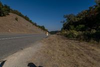 there is an empty highway on this mountain side that appears to be near a hillside