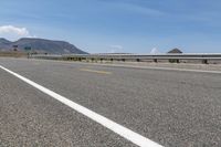 an empty highway on a sunny day in the mountains area near flagstaffs with some hills visible