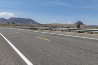 an empty highway on a sunny day in the mountains area near flagstaffs with some hills visible