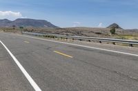 an empty highway on a sunny day in the mountains area near flagstaffs with some hills visible