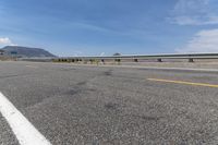 an empty highway on a sunny day in the mountains area near flagstaffs with some hills visible