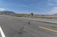 an empty highway on a sunny day in the mountains area near flagstaffs with some hills visible