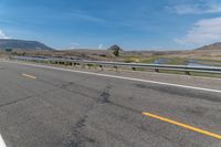 an empty highway on a sunny day in the mountains area near flagstaffs with some hills visible