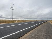 the road is wide and empty on one side, with two white lines in the middle