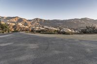 a lone, empty empty highway next to a mountainous mountainside area with trees on both sides