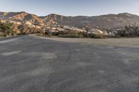 a lone, empty empty highway next to a mountainous mountainside area with trees on both sides