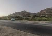 an empty highway passes a mountain and is very long way in front of it's landscape