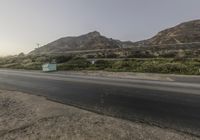 an empty highway passes a mountain and is very long way in front of it's landscape