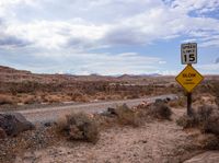 an empty highway in a desert on the side of a dirt road in front of rocks and boulders