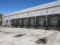 the front of an empty industrial warehouse on a sunny day, with yellow lines all over the concrete surface