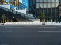 an empty intersection with several empty lounge chairs and trees in front of some building facades