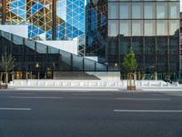 an empty intersection with several empty lounge chairs and trees in front of some building facades