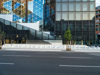 an empty intersection with several empty lounge chairs and trees in front of some building facades