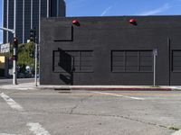 an intersection with an empty building and an empty street with traffic lights on it's sides