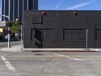 an intersection with an empty building and an empty street with traffic lights on it's sides