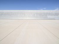 a lone jet is sitting in the middle of an empty lot of space for spectators to walk up to