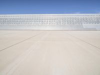 a lone jet is sitting in the middle of an empty lot of space for spectators to walk up to