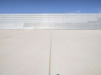 a lone jet is sitting in the middle of an empty lot of space for spectators to walk up to