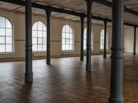 an empty large room with wooden floors and tall windows above them is a huge space in which all different types are displayed