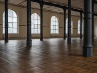 an empty large room with wooden floors and tall windows above them is a huge space in which all different types are displayed