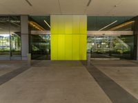 an empty lobby with two doors that open and large windows and glass on each side