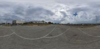 a fish eye view of the empty lot and buildings on the other side of the road