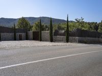 an empty lot surrounded by pine trees and mountains with lots of rock walls and windows