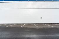 the parking lot is empty in front of an industrial building where two people are standing
