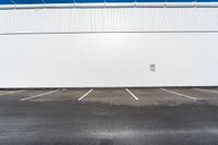 the parking lot is empty in front of an industrial building where two people are standing