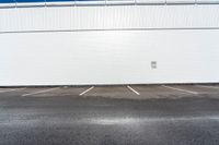 the parking lot is empty in front of an industrial building where two people are standing