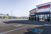 empty parking lot with handicapped signs and building in the background behind it, large business