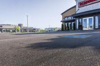 empty parking lot with handicapped signs and building in the background behind it, large business