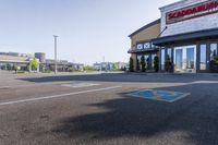 empty parking lot with handicapped signs and building in the background behind it, large business