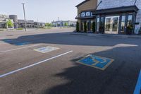 empty parking lot with handicapped signs and building in the background behind it, large business