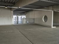 a empty building with large grey and white area with a round window in it in the middle