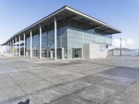 a picture of an outside building that is empty, with two levels visible and a lot of windows behind it